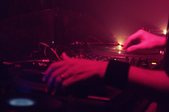 DJ hands on the decks under red light (illustration, Berlin)